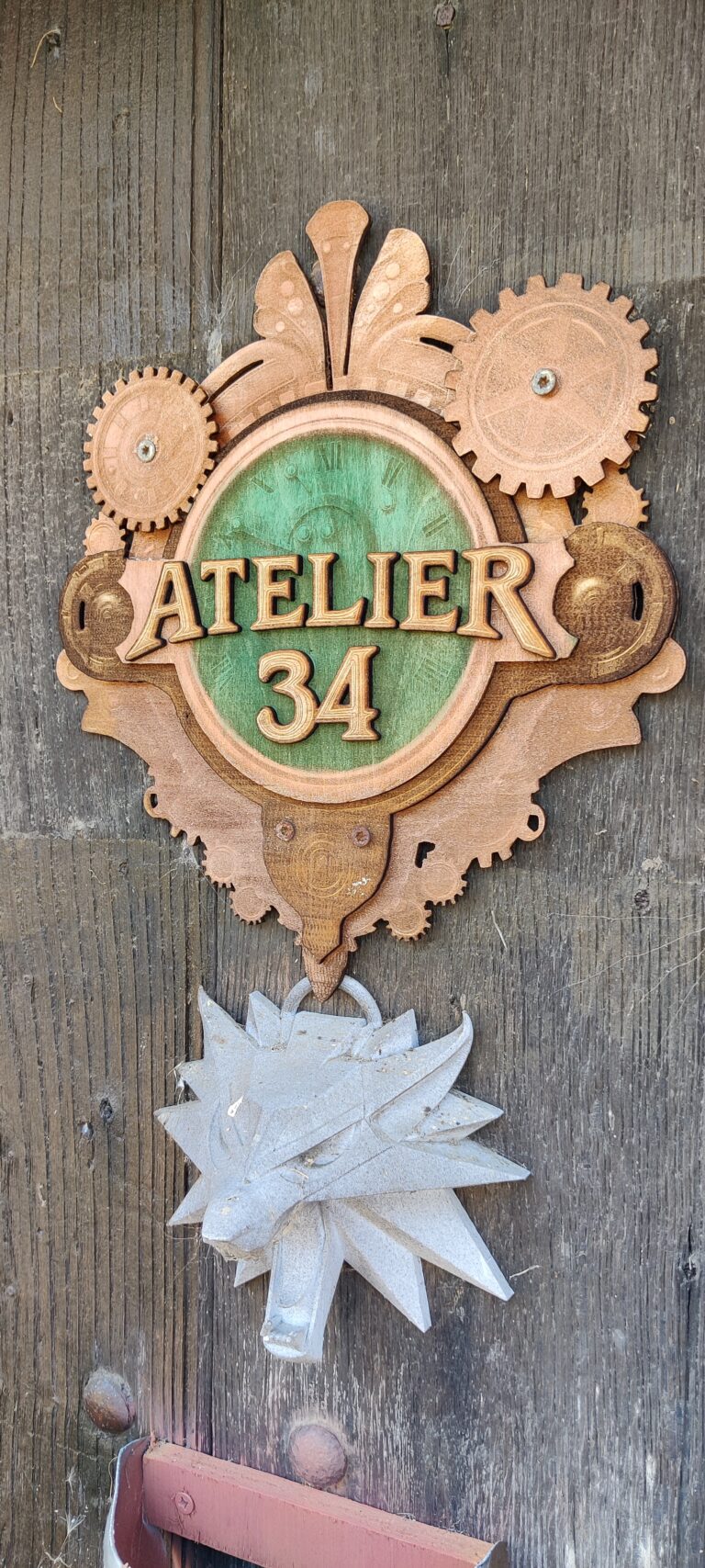 IMG_20260811_110457 ‣ Atelier 34 ‣ Atelier 34 Logo Atelier 34 en bois découpé et gravé au laser, installé sur la porte de l'atelier.