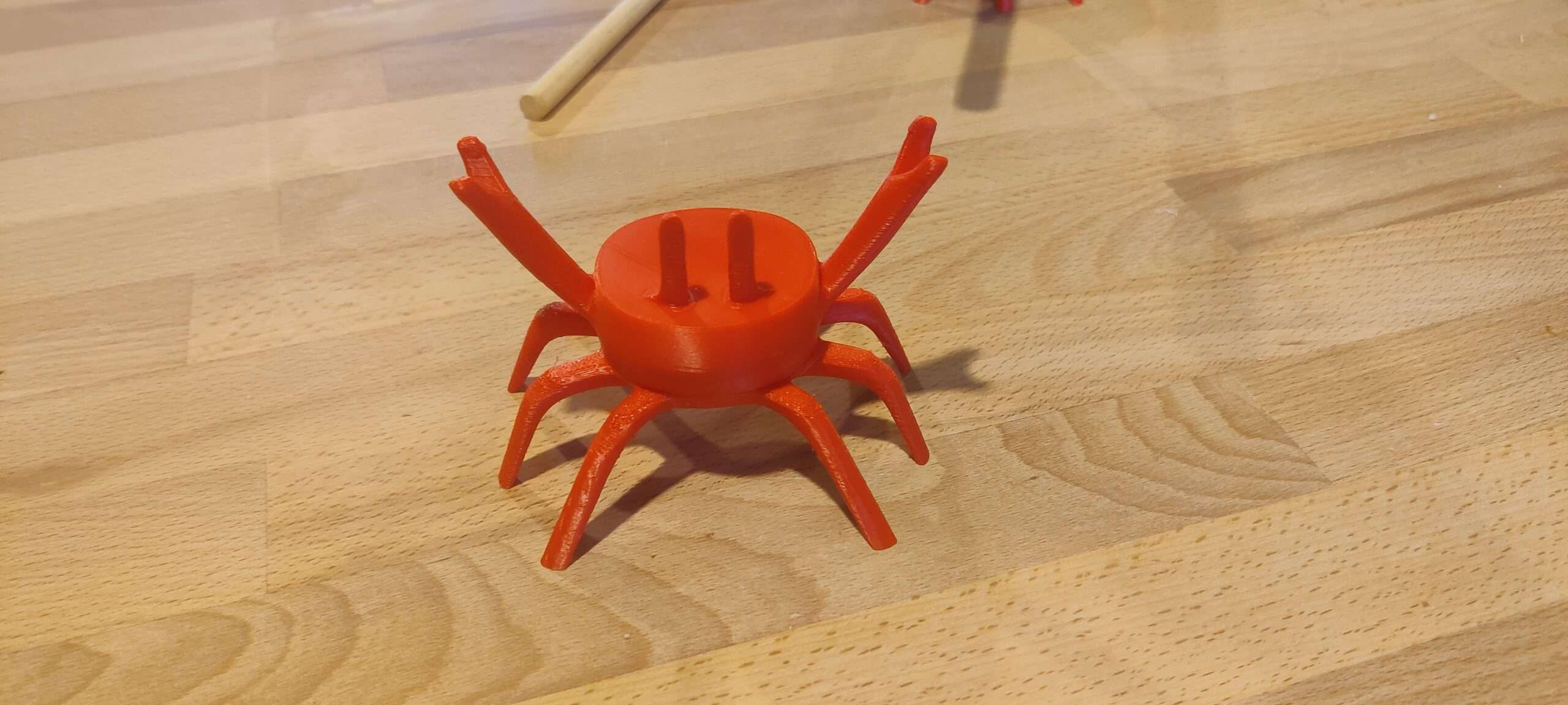 Crabe porte-cuillère en PLA – détail du support ‣ Atelier 34 Crabe porte-cuillère rouge orangé sans ustensile, avec les pinces relevées
