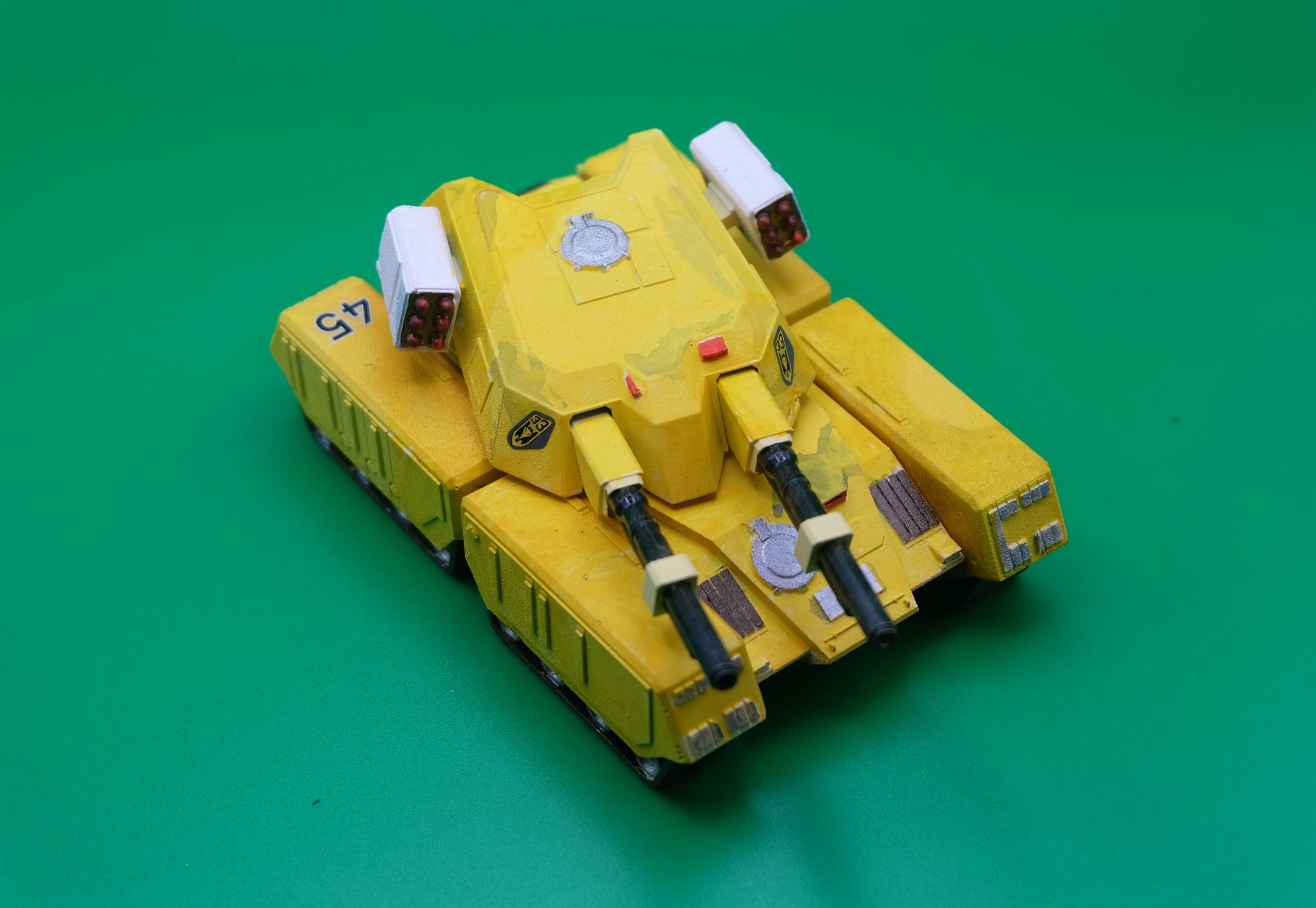 Maquette jaune du Tank Mammouth de Command & Conquer et Alerte Rouge à double canon, vue de trois quarts et du dessus.