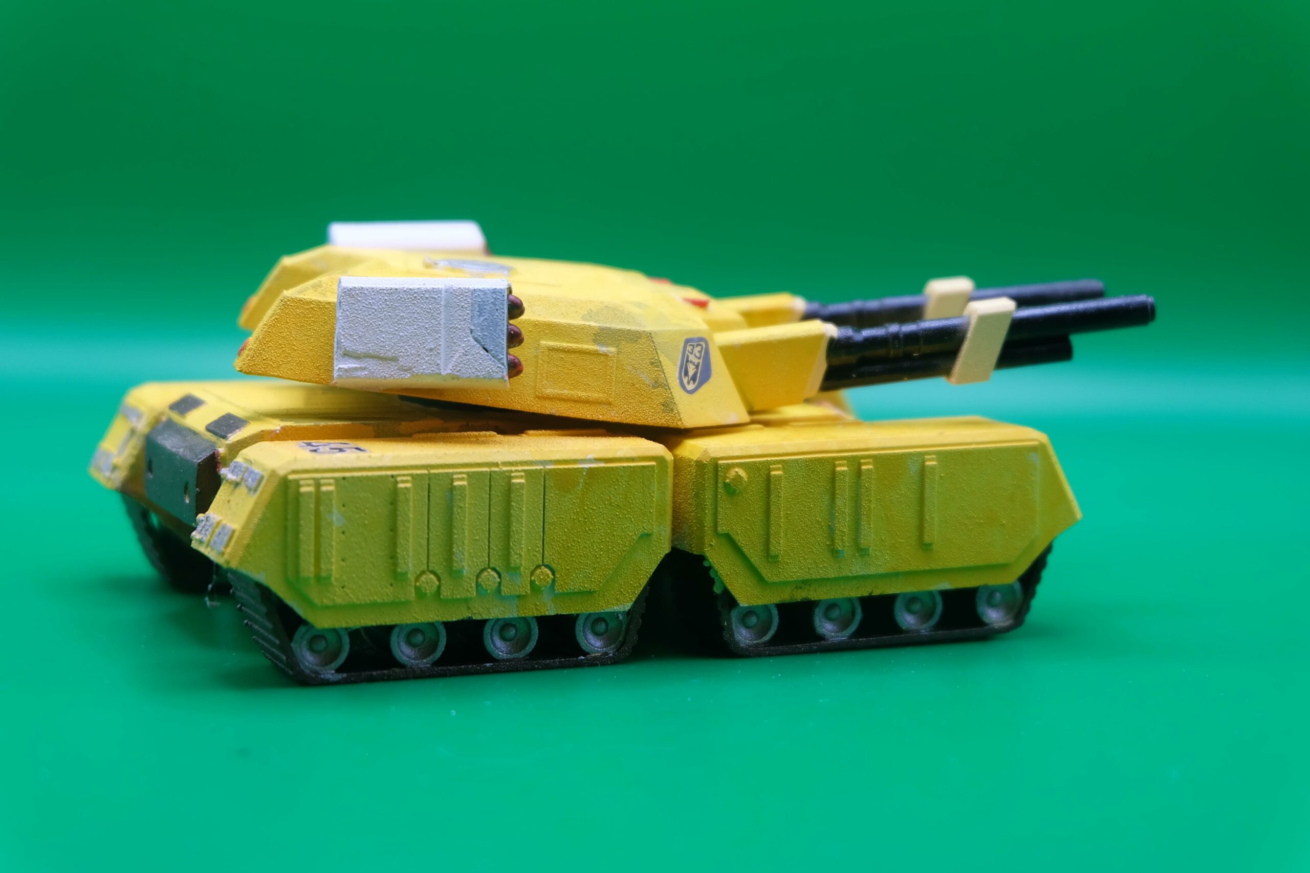 Tank Mammouth – Command & Conquer / Alerte Rouge – Vue de profil ‣ Atelier 34 Vue de profil de la maquette jaune du Tank Mammouth de Command & Conquer et Alerte Rouge, montrant les chenilles et les deux longs canons.