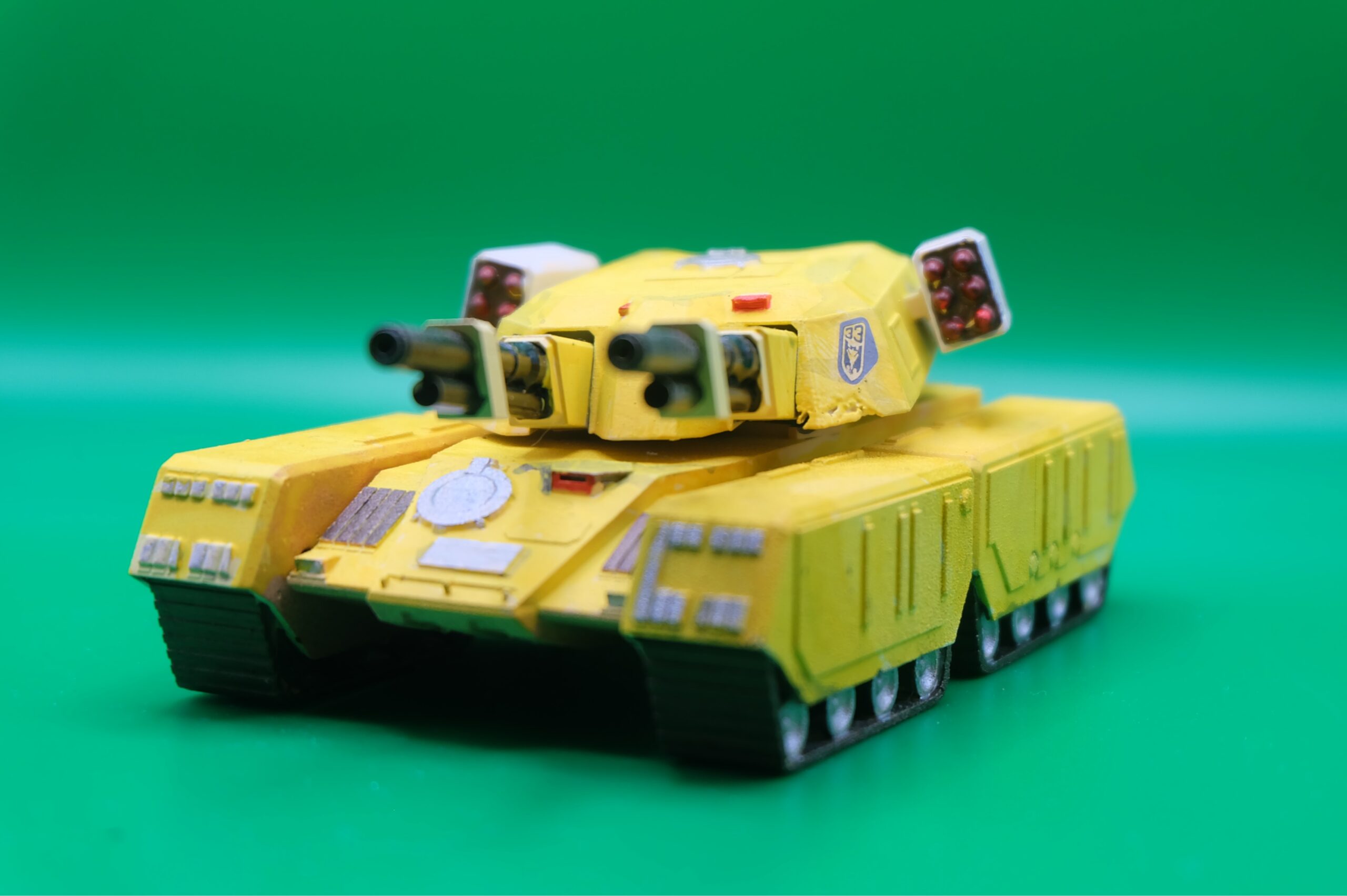 Tank Mammouth – Command & Conquer / Alerte Rouge – Vue avant ‣ Atelier 34 Vue avant de la maquette jaune du Tank Mammouth de Command & Conquer et Alerte Rouge, avec double canon et blocs de missiles latéraux.