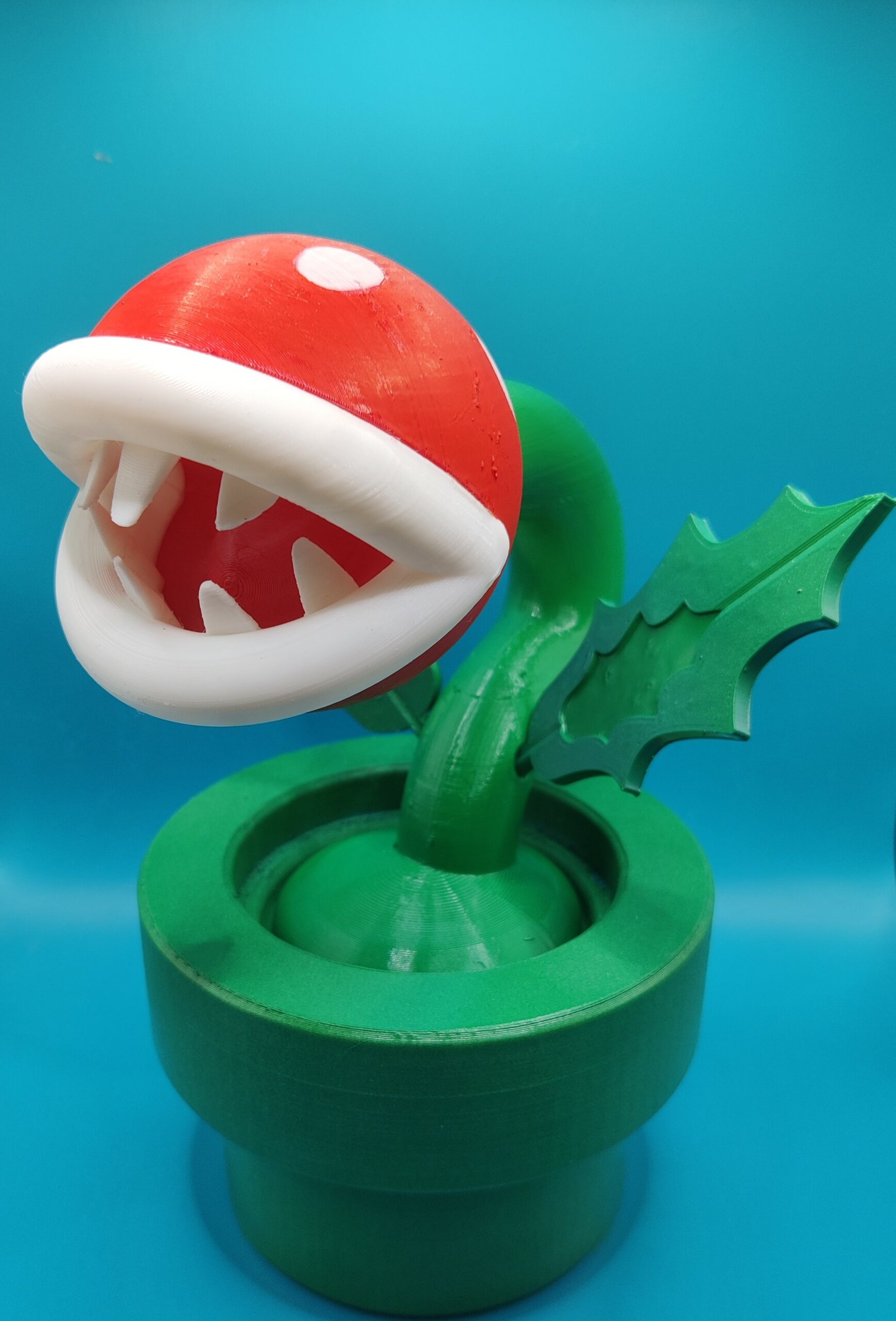 Plante Piranha Mario – Détail de la tête ‣ Atelier 34 Vue rapprochée de la tête rouge à pois blancs et des dents de la figurine de Plante Piranha.