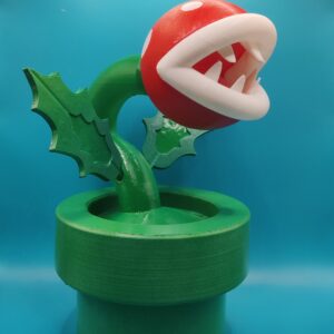 Figurine de Plante Piranha inspirée de Mario, avec tête rouge et blanche et tuyau vert, vue de trois quarts.