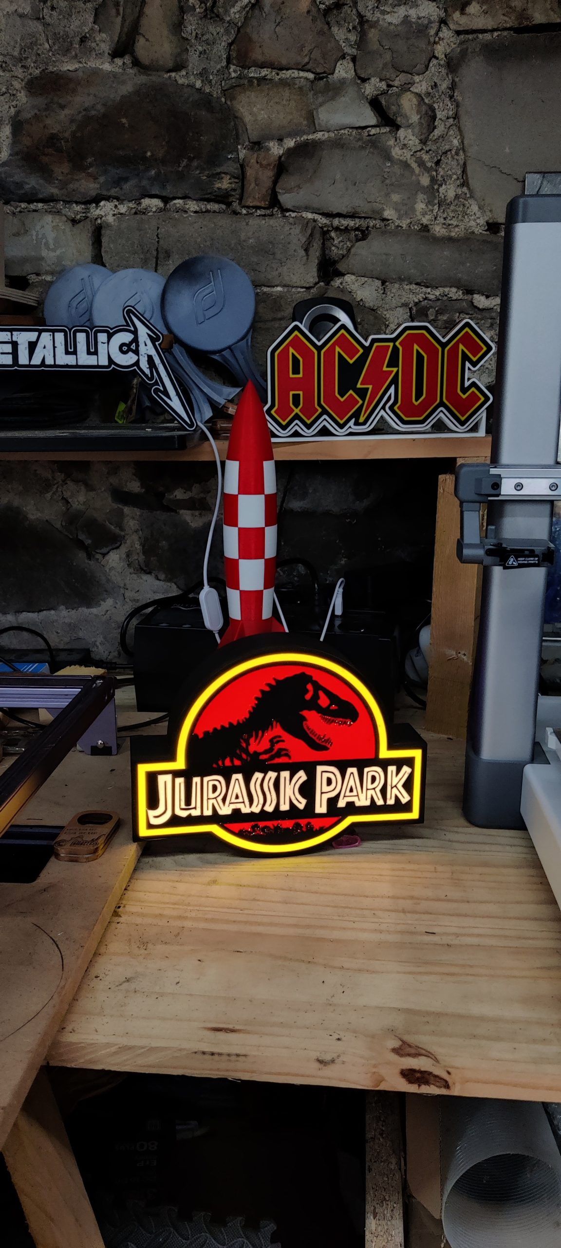 Lightbox Jurassic Park – Allumée dans l’atelier ‣ Atelier 34 Lightbox Jurassic Park allumée dans l’atelier, avec contour jaune et lettrage lumineux.