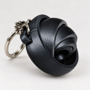 Porte-clé gyroscope articulé noir - vue principale ‣ Atelier 34 Porte-clé gyroscope articulé noir imprimé en 3D.