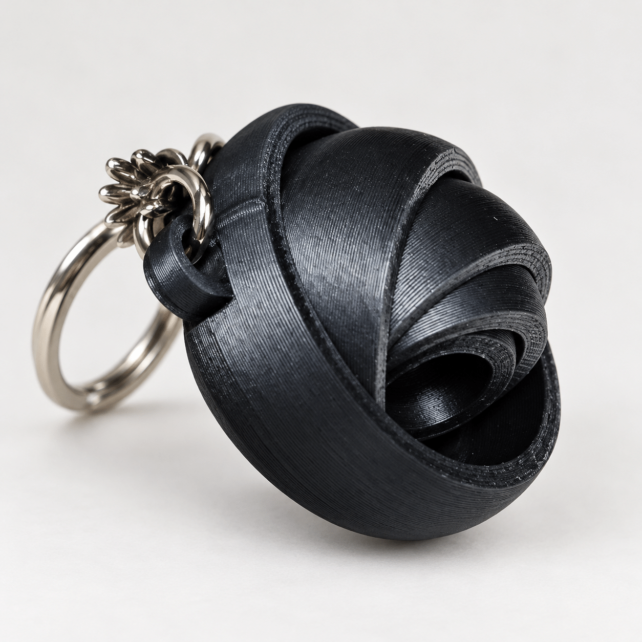 Porte-clé gyroscope articulé noir - vue principale ‣ Atelier 34 Porte-clé gyroscope articulé noir imprimé en 3D.