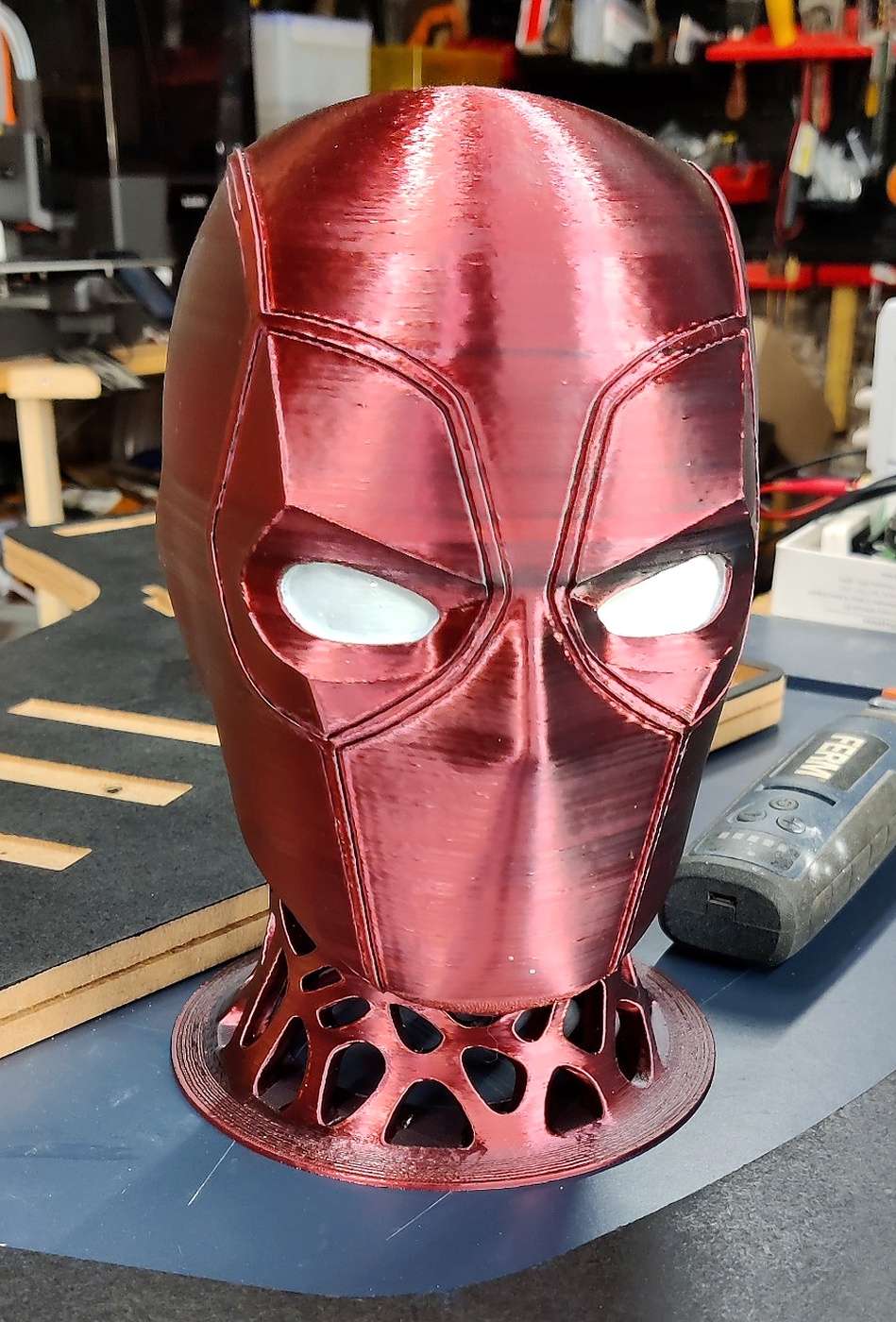 Support casque Deadpool - vue de face ‣ Atelier 34 Support de casque audio inspiré de Deadpool, vue de face avec yeux blancs peints.